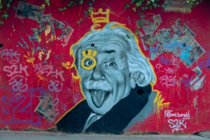 graffiti portrait of Albert Einstein who is sticking his tongue out with a graffiti crown