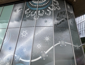 a photo of a section of giant mural featuring traditional Aboriginal designs and modern scientific symbols